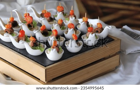 a photography of a tray of appetizers with meat and vegetables, tray of appetizers with meat and vegetables on a table.