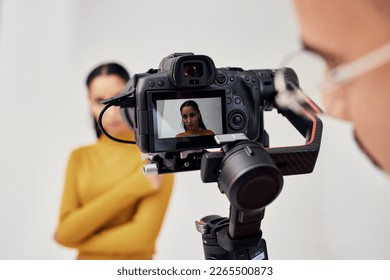 Photography, woman and photographer shoot fashion model in studio for creative, advertising and image. Media, backstage and professional man with girl and photoshoot, equipment and camera capture - Powered by Shutterstock