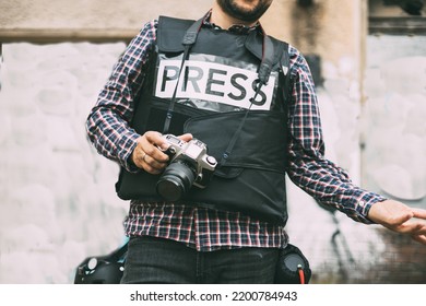 Photojournalist With Bulletproof Vest Holding His Camera	