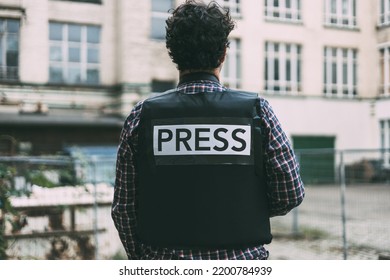 Photojournalist with bulletproof vest on his back