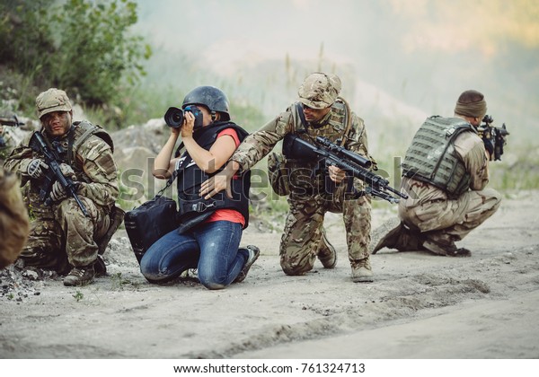 Photojournalist documenting\
war conflict. in the mountain. war, army, technology and journalist\
work concept.