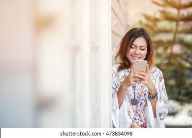 Photos Of Asian Woman Looking At The Phone And A Smiley Face Relaxed Mood,Focus On Face