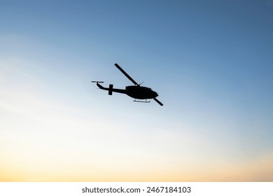 Photos of Military Helicopter flying against sunset.Flying a helicopter in the blue sunny sky - Powered by Shutterstock