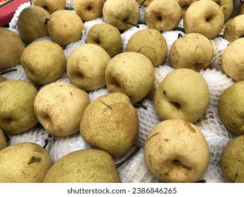 Photos of small and large pears. Pear skin looks yellowish white. There are many pears in the basket.