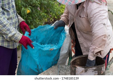 Photos of two female workers gardener helping to pick up trash in the fertilizer bag. - Shutterstock ID 1748185139