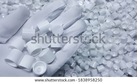 Photos of white  plastic parts for cosmetic products packing, from injection molding machines, in the plastic production department of the factory industry