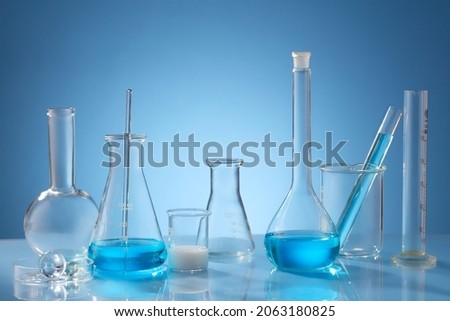 Photoshoot of science working with chemical reaction in chemistry laboratory. Blue liquid in transparent test tube and blue blackground with blank space for advertising 