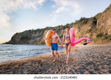 Photoshoot of young helthy beautiful caucasian couple, boy and girl, dating at the beach - Man and woman lovers having fun in holidays running near the ocean in a sunny day - Powered by Shutterstock