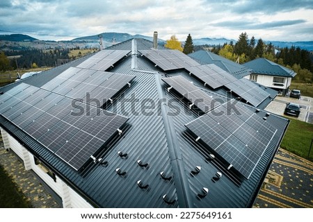 Photovoltaic solar panel system on the roof of house. Modern solar modules installed on house. Concept of alternative, renewable energy and home autonomy.