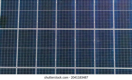 Photovoltaic solar panels on roof get clean energy from the sun. Slow motion. Aerial view. Solar Panel Array. Drone Aerial View of Modern Photovoltaic Electricity System, Close Up - Shutterstock ID 2041183487