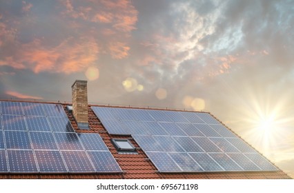 Photovoltaic Or Solar Panels On Roof At Sunset.