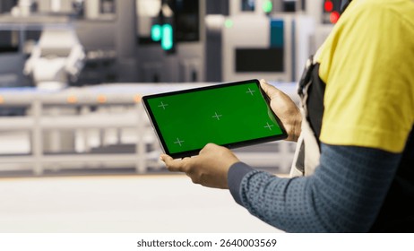 Photovoltaics plant worker uses chroma key notebook to follow maintenance procedures. Solar panels factory engineer analyzes performance data with isolated screen laptop, camera B close up