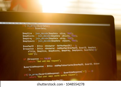 PHP back-end code in sunset rays. Computer programming source code. 