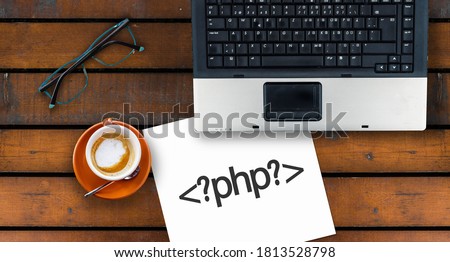 PHP programming language. Paper width PHP tag and laptop, glasses and coffee on wooden table 