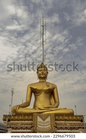 Phra Buddhachinnasi in Wat Khiriwong Temple, which has the blue sky background. The temple is located on the top of the Hill. Translation meaning thai characther is the name Phra Buddhachinnasi. 