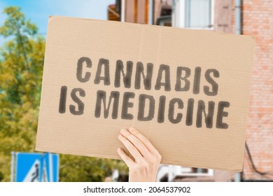 The phrase " Cannabis is medicine " on a banner in men's hand with blurred background. Protest. Street. Outdoor. Production. Approved. March. Smoking. Care. Medical