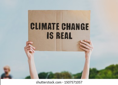 The phrase " Climate change is real " drawn on a carton banner in men's hand. Human holds a cardboard with an inscription: Climate change is real - Shutterstock ID 1507571057