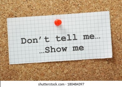 The Phrase Don't Tell Me, Show Me Typed On A Piece Of Graph Paper And Pinned To A Cork Notice Board. Often Used In Business But More So As A Guide For Novel And Book Writers.