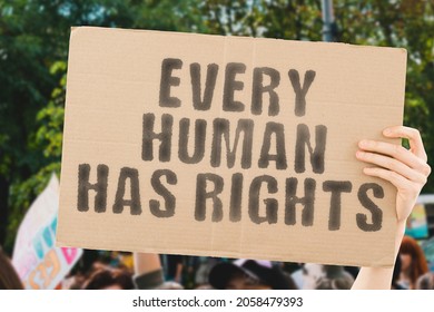 The phrase " Every human has rights " on a banner in men's hand with blurred background. Protest. Street. Equality. Law. Rules. Freedom