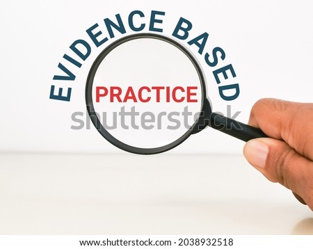 Phrase evidence based practice with hand hold magnifying glass.