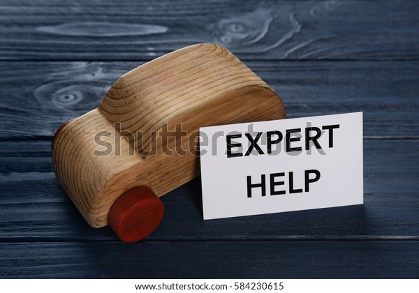 Phrase\
EXPERT HELP and toy car on wooden\
background