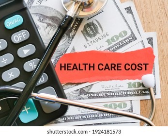 Phrase HEALTH CARE COST Written On Strip Paper With Stethoscope,calculator And Fake Money. Medical And Health Concept.