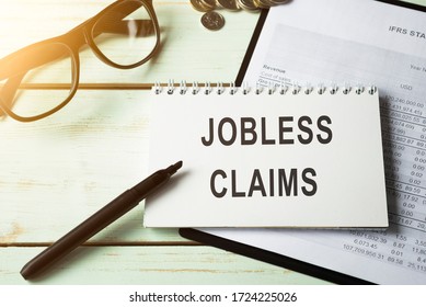 The Phrase Jobless Claims On A Banner In Hand. Human Holds A Cardboard With An Inscription. Unemployment Crisis. Economy Crashed. Financial Collapse. Recession. Finance. Employee