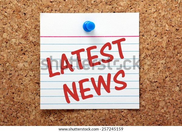 The phrase Latest News on a lined index card pinned\
to a cork bulletin board