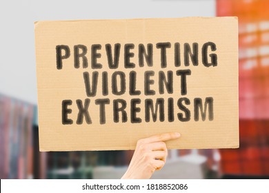 The phrase " Preventing violent extremism " on a banner in men's hand with blurred background. Dangerous. Anger. Aggressive attack. Aggression. Life. Conflict
