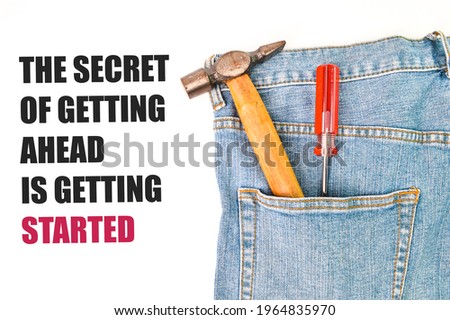 Phrase THE SECRET OF GETTING AHEAD IS GETTING STARTED written over white background with hammer, screwdriver and blue jeans