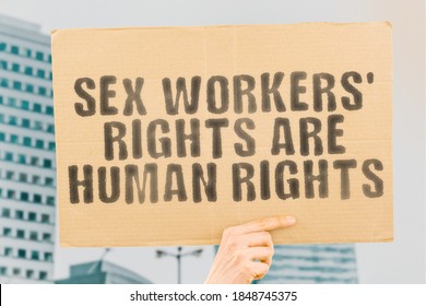 The phrase " Sex workers rights are human rights " on a banner in men's hand with blurred background. Business. Profession. Occupation. Trade. Control. Money. Earnings. Legally. Pleasure