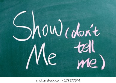 The Phrase Show Me, Don't Tell Me Written By Hand In White Chalk On A Used Blackboard. Often Used In Business But More So As A Guide For Novel And Book Writers