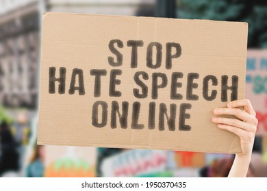 The phrase " Stop hate speech online " on a banner in men's hand with blurred background. Violence. Internet. Dangerous. Bulling. Abuse. Discrimination