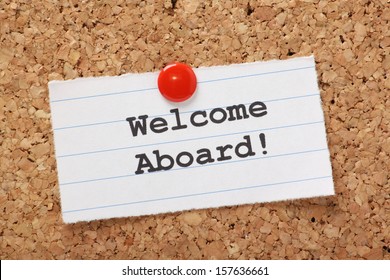 The Phrase Welcome Aboard! Typed Onto A Scrap Of Lined Paper And Pinned To A Cork Notice Board. A Phrase Used To Welcome A New Employee Or Team Member.