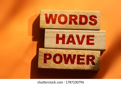 The phrase Words Have Power on wooden blocks laying on orange background. Copywriting advertising PR concept.