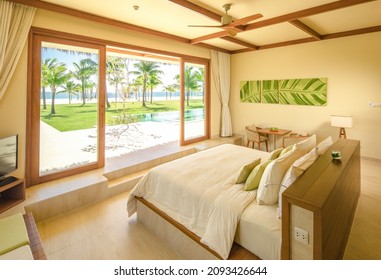 Phu Quoc City, Vietnam - October 2020: Beautiful Bright Bedroom In A Luxury Hotel With A Large Bed And Modern Furniture, Large Glass Doors Overlooking The Greenery. Luxury Resort Apartment.