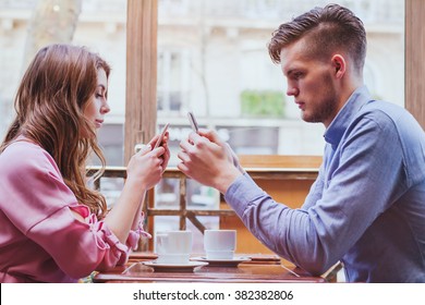 phubbing, always connected, internet addiction, young couple in cafe looking at their smartphones, social network concept