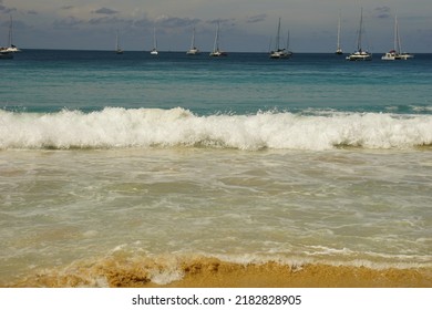 Phuket Beach In The Summer Haze With Waves And Sailing Boats In Background