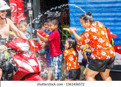 Phuket, Thailand - 13th April 2017: People on a motorbike drenched by Songkran participants. This is how Thais celebrate their new year.