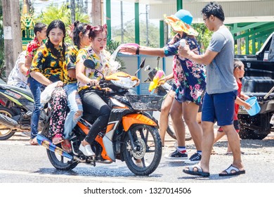 Phuket, Thailand - 13th April 2018: three girls on a motorbike being sprayed with water. Songkran is the Thai new year celebration.