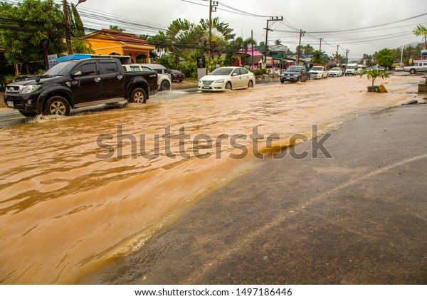 Phuket, Thailand - Aug 2015: Thailand flood.
Flooded streets and roads in Phuket island after passing a tropical
cyclone with storm, typhoon and hurricane. Cars and motorcycles
ride on wheels in water