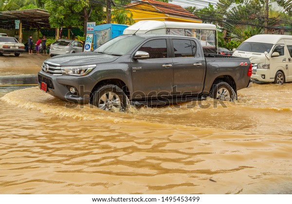Phuket, Thailand - Aug 2015:Flooding in Thailand.\
Huge and deep puddles after tropical storm, cyclone and typhoon.\
Flooded streets in Phuket. Pickups, cars, buses and motorcycles\
ride in the water