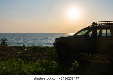 Phuket Thailand January 22,2024:Brown American SUV Jeep Grand Cherokee WJ 2002 on the beach sunset sky background in Phuket island Thailand,Travel and camping concept transportation background