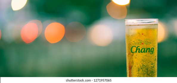 PHUKET, THAILAND - JULY 24, 2018: glass of favorite thai beer, chang, with beautiful light bokeh as background