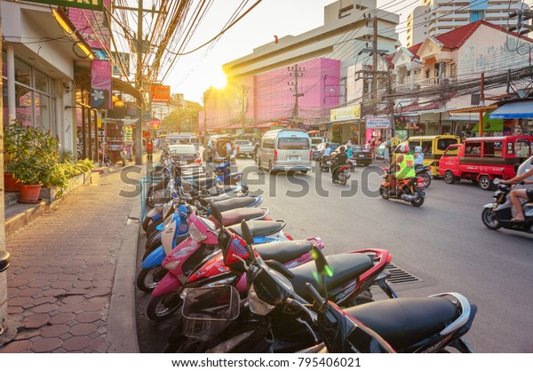 Phuket, Thailand - March, 2014: A street in Phuket\
city. Motobikes parked in a row close-up on a city road with\
institutions and shops.