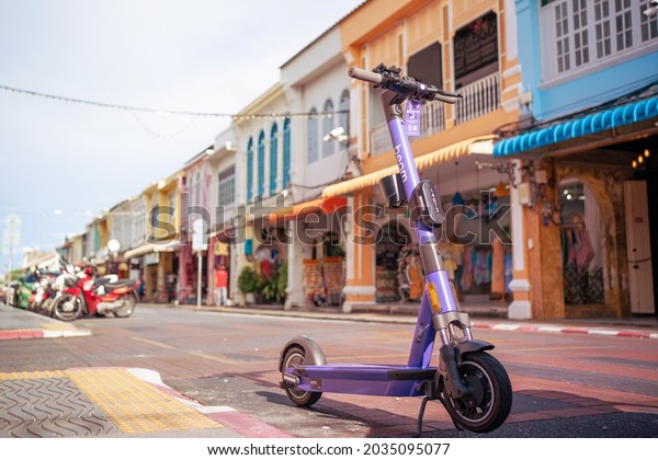 PHUKET,THAILAND-CIRCA JULY,2021: Phuket smart\
city. Tourism Island of Sustainable growth by enhancing.Driving\
electric bike in Phuket old town famous\
places.