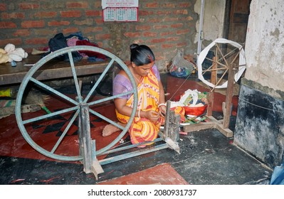 Phulia, West Bengal, 09-08-2021: A Housewife Spinning Cotton Threads With Help Of Manually Operated Charkha (spinning Wheel). Condition Of Economic Hardship Are Evident From Her Simple Lifestyle.