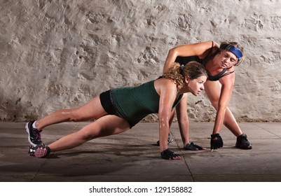 Physical fitness trainer with woman doing right angle pushups - Powered by Shutterstock