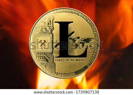 Physical Litecoin gold coin (LTC) with fire or flame background. Cryptocurrency bull market growth with rising prices.