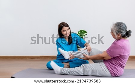 Physical therapist Asian woman, doing leg physiotherapy for elderly woman, to treat osteoarthritis and nerve pain in the leg, to nursing home and health care concept.